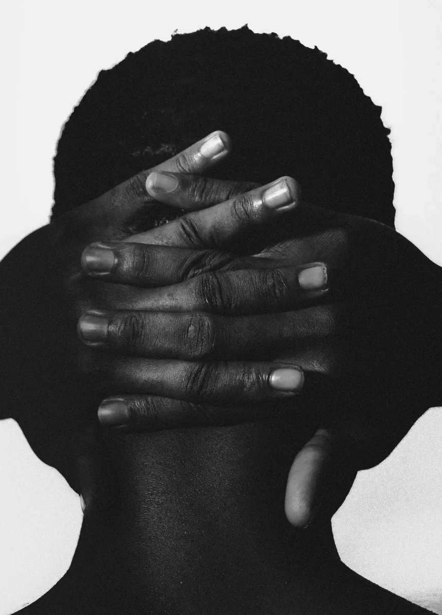 Monochrome portrait of a person with hands covering their face — symbolising the vulnerability and importance of building brand identity and trust for early-stage startups.