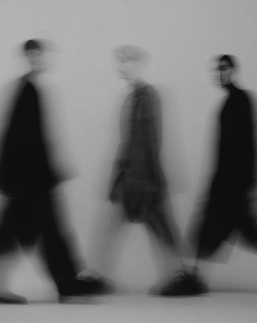 A blurred black-and-white image of people walking in motion, symbolizing uncertainty and transition—reflecting the importance of strong company culture during times of economic instability or recession.
