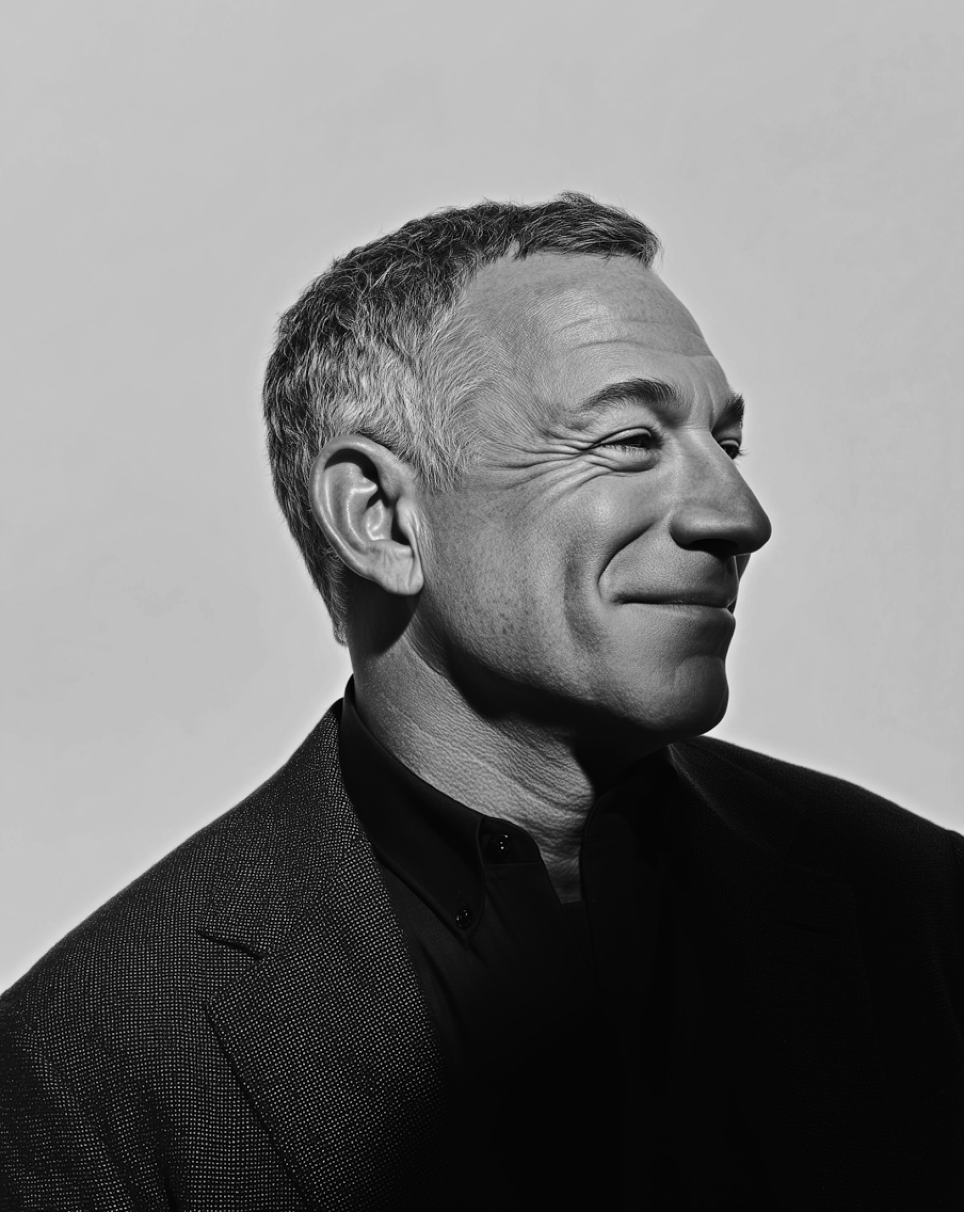 Black-and-white portrait of a smiling man in a suit, representing confident brand communication that captures investor attention.