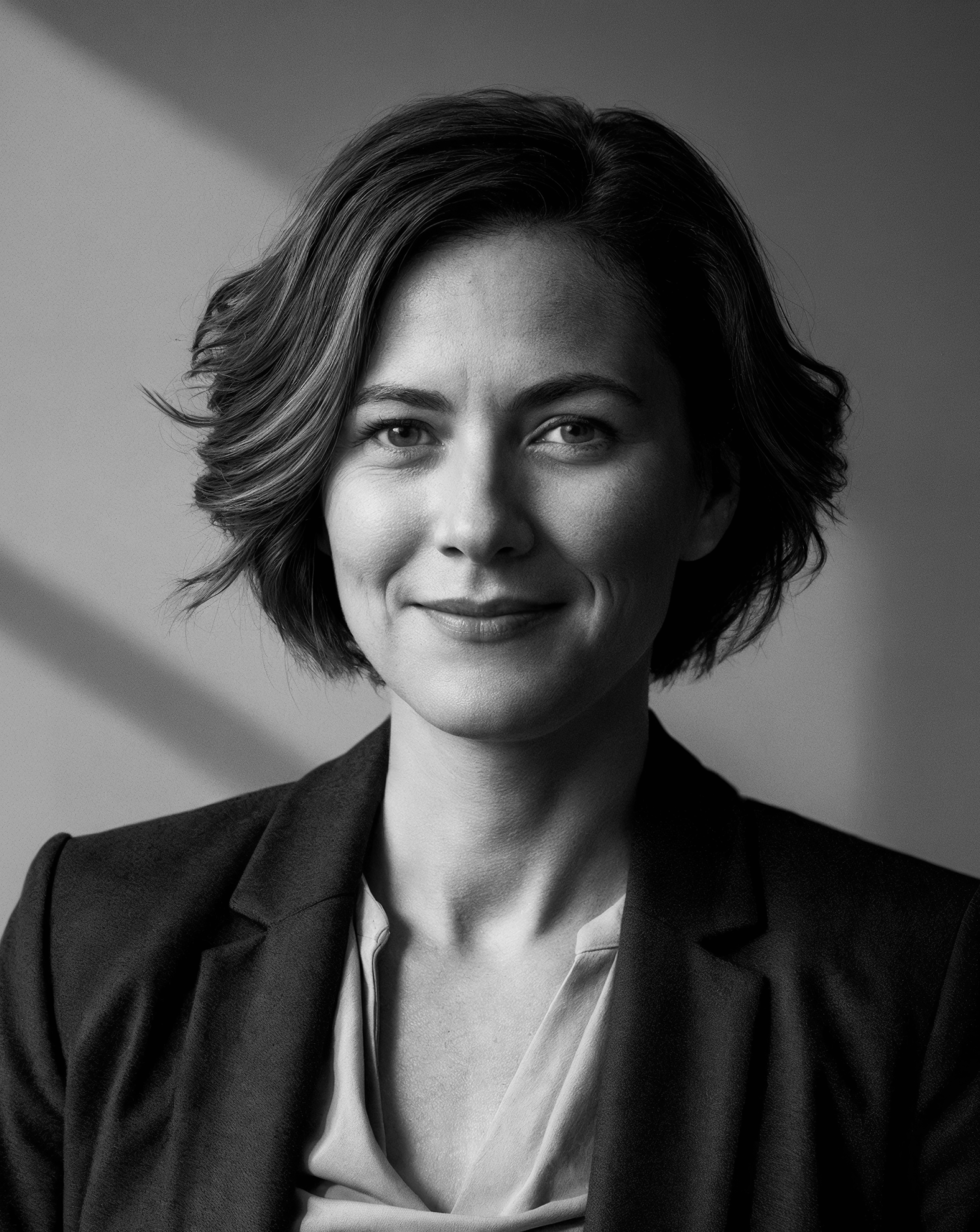Black-and-white portrait of a confident woman in business attire, symbolizing investor trust built through clear, brand-led communication.